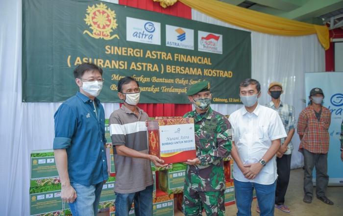 Aster Kakostrad, Heri Susanto (kedua kanan) turut membantu memberikan paket sembako dari Asuransi Astra kepada perwakilan warga yang hadir.